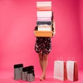 Beautiful young woman with shopping bags and boxes isolated on pink. Royalty Free Stock Photo