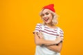 Beautiful young woman with short blonde curly hair and bright makeup in white overalls and red hat gesticulated and