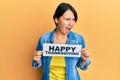 Beautiful young woman with short hair holding happy thanksgiving message paper angry and mad screaming frustrated and furious,