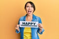 Beautiful young woman with short hair holding happy thanksgiving message paper angry and mad screaming frustrated and furious,