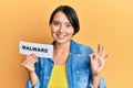 Beautiful young woman with short hair holding malware paper doing ok sign with fingers, smiling friendly gesturing excellent