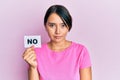 Beautiful young woman with short hair holding no word message thinking attitude and sober expression looking self confident