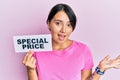 Beautiful young woman with short hair holding special price message celebrating achievement with happy smile and winner expression