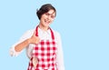 Beautiful young woman with short hair wearing professional cook apron doing happy thumbs up gesture with hand Royalty Free Stock Photo