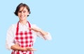 Beautiful young woman with short hair wearing professional cook apron gesturing with hands showing big and large size sign, Royalty Free Stock Photo