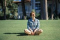 Beautiful young woman with short haircut enjoying nature and yoga meditation outdoors aon green lawn in sunny summer day. Healthy Royalty Free Stock Photo