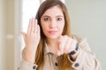 Beautiful young woman showing engagement ring on hand pointing with finger to the camera and to you, hand sign, positive and Royalty Free Stock Photo