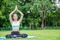 Beautiful young woman sit meditation doing yoga in park. Relaxing and meditating while being surrounded by nature in summer park Royalty Free Stock Photo