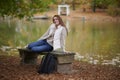 Beautiful young woman sits on college campus in fall alone Royalty Free Stock Photo