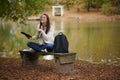 Beautiful young woman sits on college campus in fall alone Royalty Free Stock Photo