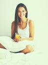 Beautiful young woman sitting in bed and having breakfast Royalty Free Stock Photo