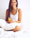 Beautiful young woman sitting in bed and having breakfast Royalty Free Stock Photo