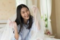 Beautiful woman sitting on the bed, smiling happily playing with some gauze veil on her head Royalty Free Stock Photo