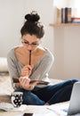 Beautiful young woman sitting on bed, working. Home office. Royalty Free Stock Photo