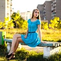 Beautiful young woman sitting on a bench in a city park at sunny Royalty Free Stock Photo