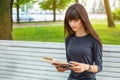 Beautiful young woman sitting on a bench in the street reading a book Royalty Free Stock Photo