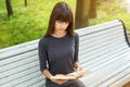 Beautiful young woman sitting on a bench in the street reading a book Royalty Free Stock Photo