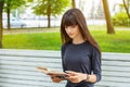 Beautiful young woman sitting on a bench in the street reading a book Royalty Free Stock Photo