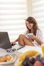 Woman using laptop computer while having breakfast Royalty Free Stock Photo