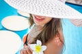 Beautiful young woman sitting on the edge of the pool Royalty Free Stock Photo