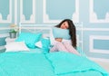 Beautiful young woman sitting embracing pillow on a bed Royalty Free Stock Photo