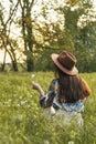 Beautiful Young Woman sitting on the field in green grass and blowing dandelion. Outdoors. Enjoy Nature. Healthy Smiling Girl on Royalty Free Stock Photo