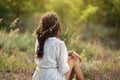 Beautiful young woman sitting in a wheat field in the summer sunset. Beauty and summer concept Royalty Free Stock Photo