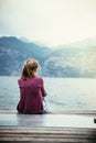 Beautiful young woman is sitting on a footbridge and enjoying the view, vacation