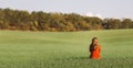 Beautiful young woman sitting on green grass in autumn clothing, girl relax in solitude on nature Royalty Free Stock Photo