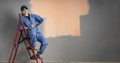 Beautiful young woman sitting on ladder doing wall painting and looking at camera. Space for text Royalty Free Stock Photo