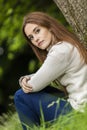 Beautiful Young Woman Sitting Leaning Against Tree Royalty Free Stock Photo