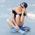 Beautiful young woman sitting on longboard Royalty Free Stock Photo