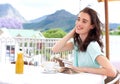 Beautiful young woman sitting outside at cafe with book Royalty Free Stock Photo