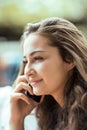 Beautiful young woman sitting outside having a conversation on her cell phone Royalty Free Stock Photo