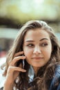 Beautiful young woman sitting outside having a conversation on her cell phone Royalty Free Stock Photo