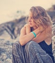 Beautiful young woman sitting on the rocks at sunset Royalty Free Stock Photo