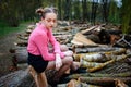 Beautiful young woman sitting on stack of felled tree trunks in the forest Royalty Free Stock Photo