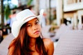 Beautiful young woman sitting on sunbed with the hat on the beach resort, summer vacation