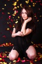 Beautiful young woman sitting under the falling petals Royalty Free Stock Photo