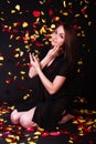 Beautiful young woman sitting under the falling petals Royalty Free Stock Photo