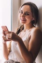 Beautiful young woman sitting on the windowsill listen to music Royalty Free Stock Photo