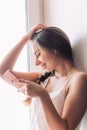 Beautiful young woman sitting on the windowsill listen to music Royalty Free Stock Photo