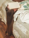 Beautiful young woman sleeping on bed with book covering her face because reading book with preparing exam of college Royalty Free Stock Photo