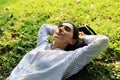 Woman smile portrait and sleeping relaxation on green grass in the public park. Royalty Free Stock Photo