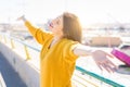 Beautiful young woman smiling with closed eyes and open arms enjoying the sunlight on a sunny day. Happy sunbathe Royalty Free Stock Photo