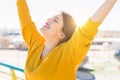 Beautiful young woman smiling with closed eyes and open arms enjoying the sunlight on a sunny day. Happy sunbathe Royalty Free Stock Photo