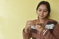 Beautiful young woman smiling and eating nuts at home. Healthy concept Royalty Free Stock Photo