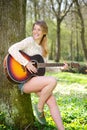 Beautiful young woman smiling with guitar outdoors Royalty Free Stock Photo