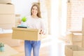 Beautiful young woman smiling happy moving to a new home, very excited holding cardboard boxes at new apartment Royalty Free Stock Photo