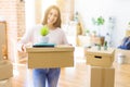 Beautiful young woman smiling happy moving to a new home, very excited holding cardboard boxes at new apartment Royalty Free Stock Photo